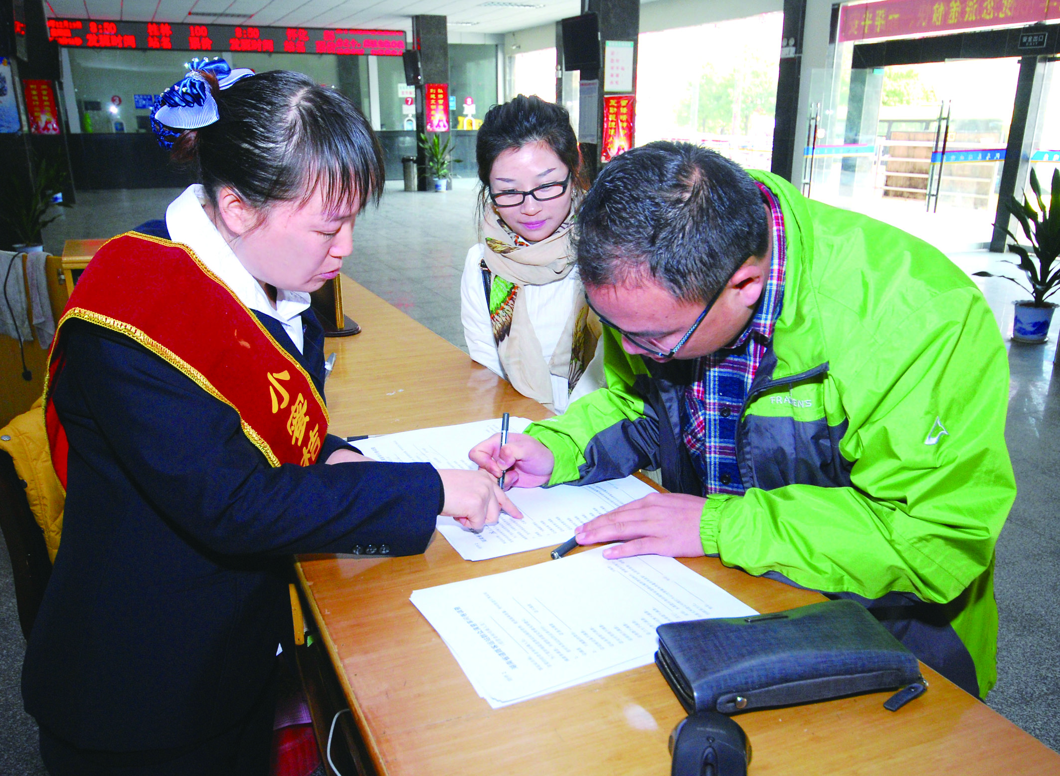 圖為洞口汽車(chē)總站站務(wù)人員在熱心為旅客服務(wù)。